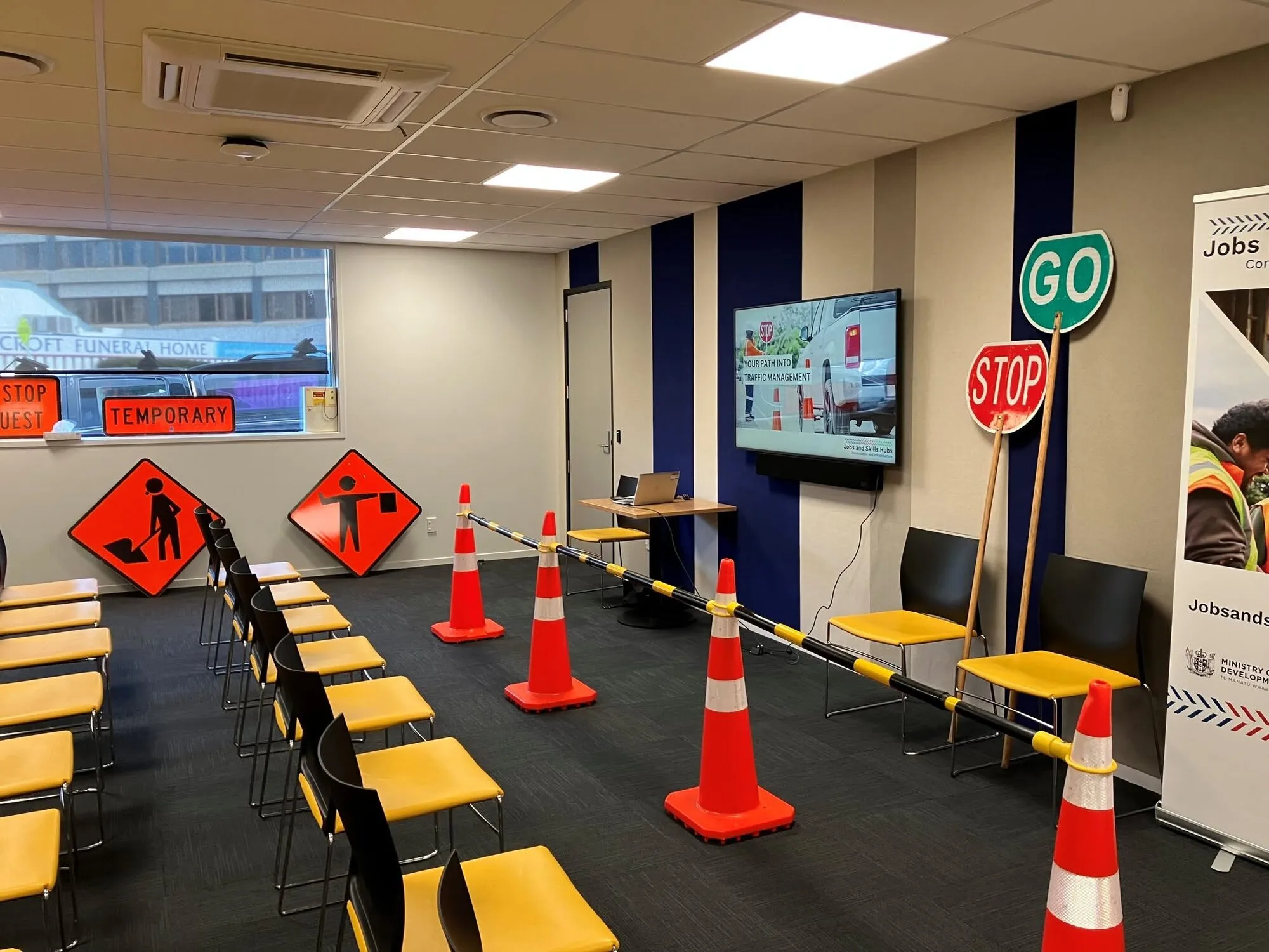 A traffic management training room at the Jobs and Skills Hub, with road signs, cones and rows of chairs